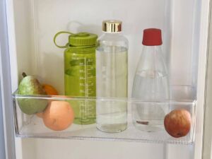 2 sklenené a jedna plastová flaša plná vody v chladničke.